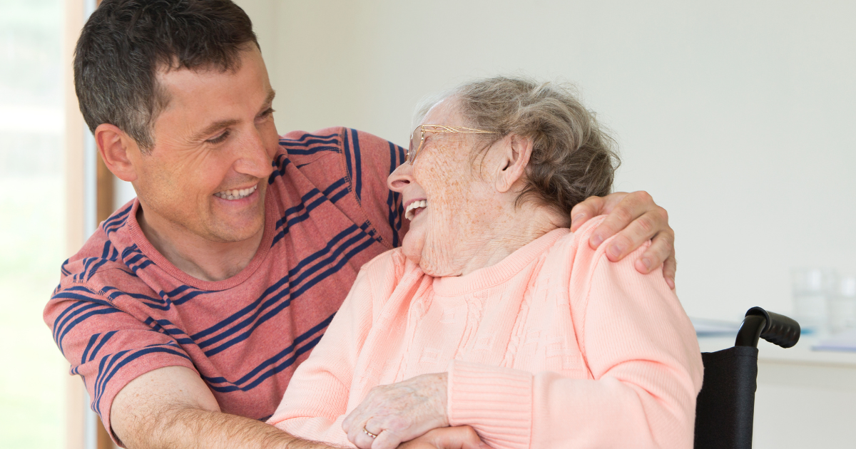 A professional home caregiver and elderly woman laughing