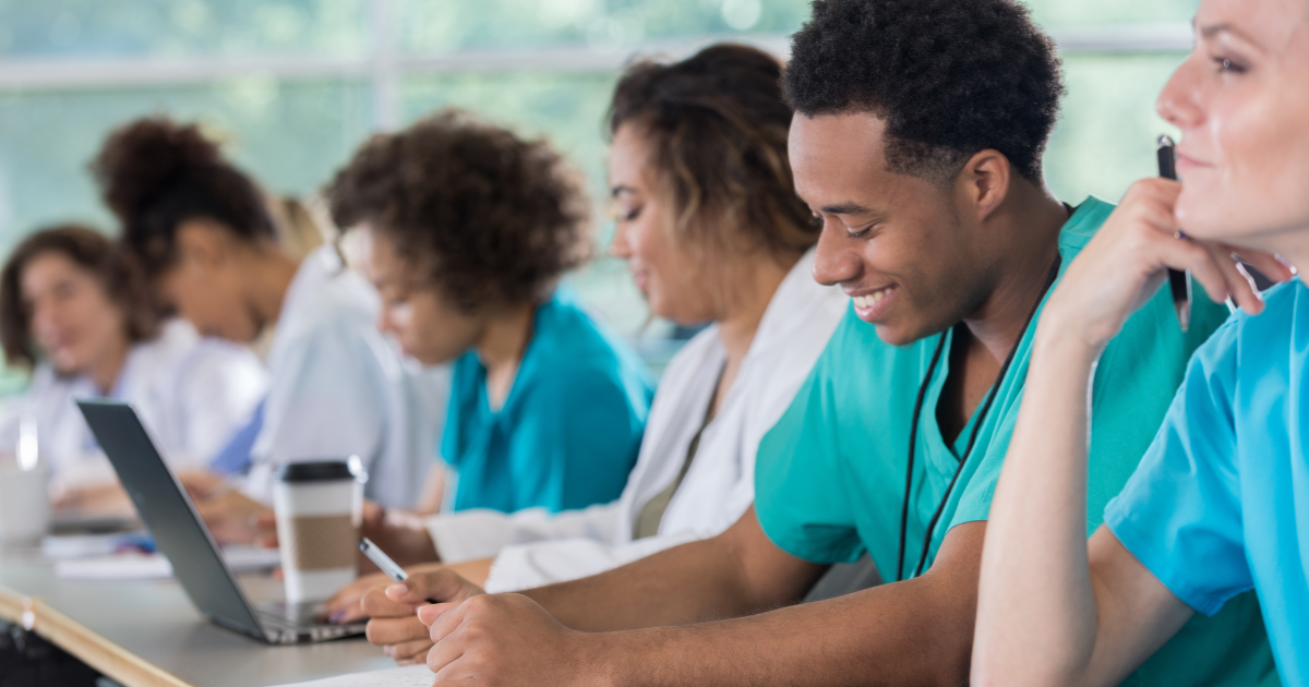 CNA students take notes as they take a class to further develop their skills.