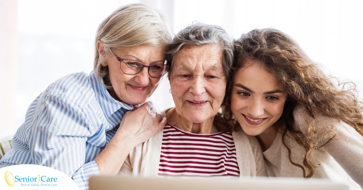 Three generation embrace and look at a computer, representing the sandwich generation.