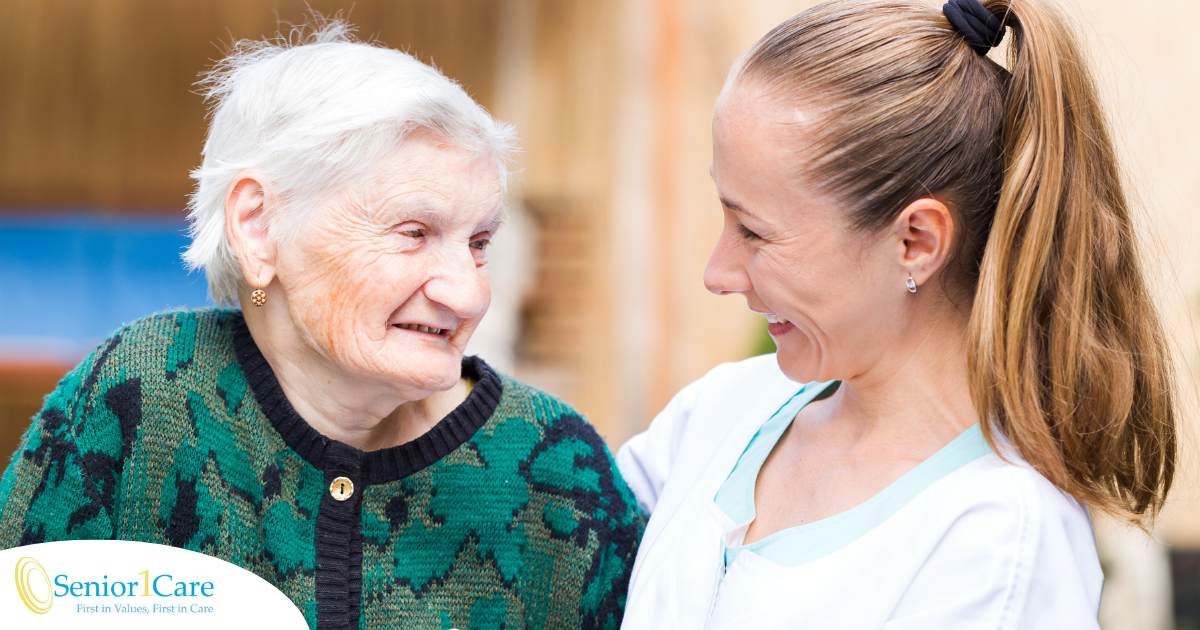 A professional caregiver compassionately hugs a senior client.