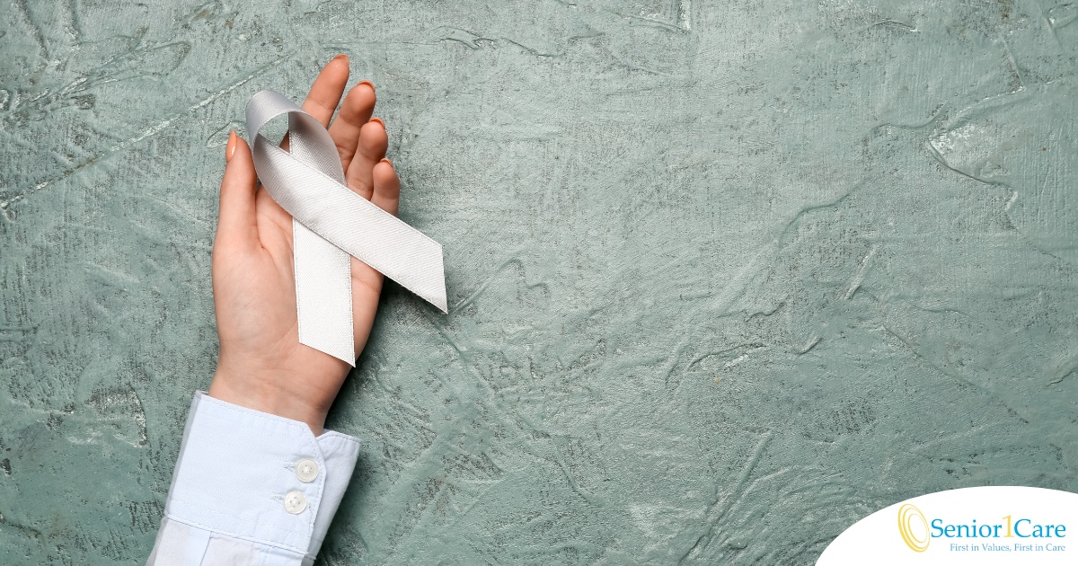 A woman holds a silver ribbon, representing Parkinson’s Awareness Month.