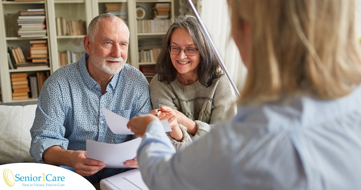 An older couple receives and considers papers from a woman, representing someone considering long-term care insurance.