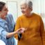 A caregiver helps a client get around, demonstrating one of the job duties of a caregiver.