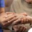 A care provider examines an older adult’s fingers, representing what would happen in an examination for rheumatoid arthritis.