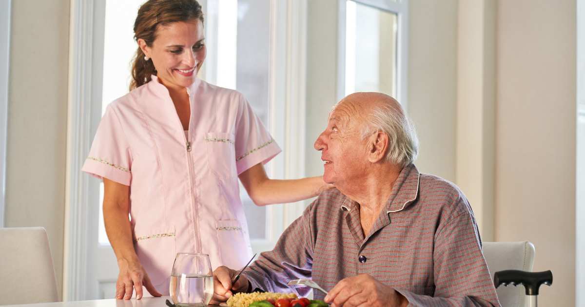A compassionate Senior1Care caregiver assisting an elderly man with meal preparation and healthy eating support in Mishawaka.