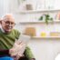 Home caregiver assisting senior man to use telehealth and senior care
